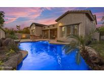 Inviting pool with waterfall feature at twilight at 501 E Sunburst Ln, Tempe, AZ 85284