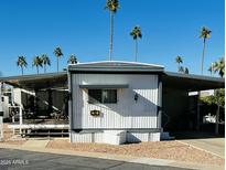 Mobile home exterior with covered patio and desert landscaping at 4065 E University Dr # 140, Mesa, AZ 85205
