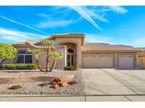 Tan two-story house with a two-car garage and desert landscaping at 19869 N 86Th Ave, Peoria, AZ 85382