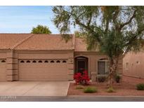 Charming single-story home featuring a well-maintained front yard with a mature tree and a two-car garage at 2101 S Yellow Wood Dr # 60, Mesa, AZ 85209