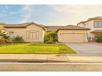 Charming single-story home featuring a tile roof, well-maintained lawn, and an attached two-car garage at 755 E Orchid Ln, Gilbert, AZ 85296