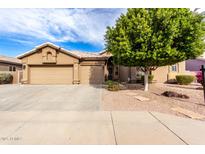 Tan two-story house with a three-car garage and nicely landscaped front yard at 9354 E Hillview Cir, Mesa, AZ 85207