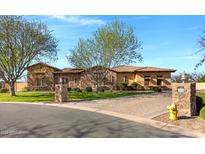 Charming single-story home featuring a stone facade, terracotta roof, and professionally landscaped front yard at 24002 S 201St Ct, Queen Creek, AZ 85142