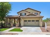 Charming two-story home with a desert landscape, a covered porch, and a two-car garage at 2542 N Riley Rd, Buckeye, AZ 85396