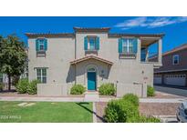 Two-story stucco home with teal front door and landscaped lawn at 4718 E Thunderheart Trl # 103, Gilbert, AZ 85297