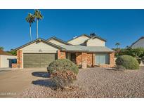 Brick home with a two-car garage and well-manicured landscaping at 6444 E Paradise Ln, Scottsdale, AZ 85254