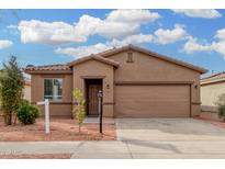 Single-story house with a two-car garage and landscaping at 6903 W Irwin Ave, Laveen, AZ 85339