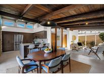 Mid-century modern dining area with wood table and chairs, adjacent to kitchen at 4216 N 38Th St # C, Phoenix, AZ 85018