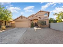 Two-story house with tan exterior, double garage, and landscaped front yard at 9377 E Corrine Dr, Scottsdale, AZ 85260