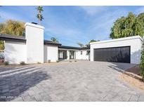 Modern home exterior with white brick, black accents, and a paver driveway at 342 E Orangewood Ave, Phoenix, AZ 85020