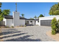 Modern home with white brick accents, dark trim, spacious gray brick driveway, and desert landscaping at 342 E Orangewood Ave, Phoenix, AZ 85020