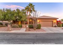 Inviting single-story home featuring a lush, landscaped front yard with desert plants and a two car garage at 3799 N 154Th Dr, Goodyear, AZ 85395