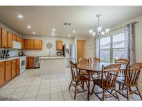 Eat-in kitchen with wood cabinets, island, and stainless steel appliances at 11526 W Scotts Dr, El Mirage, AZ 85335