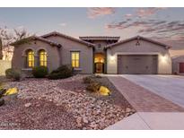 Single-story home with desert landscaping and a three-car garage at 1228 N 102Nd St, Mesa, AZ 85207