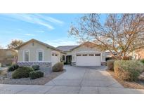 House exterior featuring a two-car garage and mature trees at 7873 W Fetlock Trl, Peoria, AZ 85383