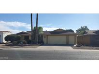 Tan house with a two-car garage and nicely landscaped yard at 13359 W Ballad Dr, Sun City West, AZ 85375