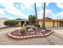 Single-story home featuring desert landscaping, palm trees, and a brick walkway leading to the front door at 13359 W Ballad Dr, Sun City West, AZ 85375