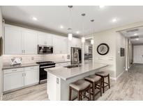 Modern kitchen with white cabinets, quartz countertops, and stainless steel appliances at 20385 W Vista Paseo Dr, Buckeye, AZ 85396