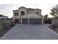 Two-story house with a three-car garage and landscaped front yard at 4913 W Pedro Ln, Laveen, AZ 85339