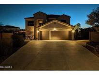 Two-story house with a three-car garage, illuminated at night at 4913 W Pedro Ln, Laveen, AZ 85339