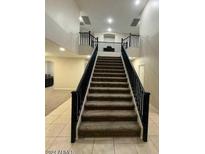 Impressive grand staircase with dark wood railings at 12525 W Winslow Ave, Avondale, AZ 85323