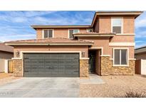 Two-story house with stone accents and a two-car garage at 24758 W Huntington Dr, Buckeye, AZ 85326