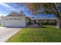 Ranch style home with attached garage and well-manicured lawn at 10113 W Kingswood Cir, Sun City, AZ 85351