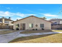 Tan stucco house with a walkway and small lawn at 1210 N 85Th Pl, Scottsdale, AZ 85257