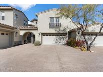 Charming home featuring a spacious driveway, two-car garage, desert landscaping, and a balcony with iron railings at 20802 N Grayhawk Dr # 1087, Scottsdale, AZ 85255