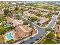 Aerial view of a community with houses, pools, and a golf course at 7710 E Monica Dr, Scottsdale, AZ 85255