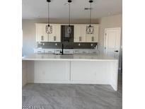 Bright kitchen features a large center island, pendant lighting, white cabinetry, and stainless steel appliances at 1224 W Howe St, Tempe, AZ 85281