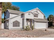 Two-story house with a white exterior, two-car garage, and desert landscaping at 1628 E Kent Ave, Chandler, AZ 85225