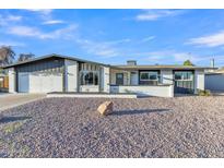Charming single story home with gravel yard, two car garage and freshly painted white exterior at 2364 W Emelita Ave, Mesa, AZ 85202