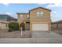 Tan two-story house with attached garage and landscaping at 9202 W Cambridge Ave, Phoenix, AZ 85037