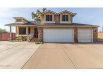 Two-story house with a brick facade, three-car garage, and landscaped front yard at 8934 W Ocotillo Rd, Glendale, AZ 85305