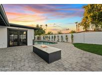 Sunset view of backyard with pool and fire pit at 1302 W Golden Ln, Phoenix, AZ 85021