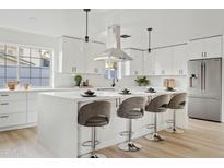 Modern white kitchen with island, stainless steel appliances, and breakfast bar at 1302 W Golden Ln, Phoenix, AZ 85021