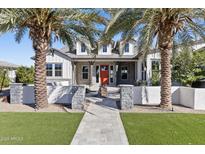 Stunning home exterior with an orange door, manicured lawn, and regal palm trees on a clear, sunny day at 19702 E Melissa Pl, Queen Creek, AZ 85142