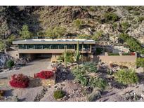 Stunning aerial view of modern home nestled into mountainside with pool and expansive views at 5800 E Glen Dr, Paradise Valley, AZ 85253