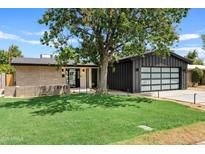 Modern mid-century home with a dark gray garage and spacious lawn at 6733 N 14Th St, Phoenix, AZ 85014