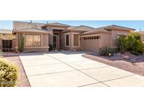 Single-story home with a large driveway and desert landscaping at 8141 E Apache Plumb Dr, Gold Canyon, AZ 85118