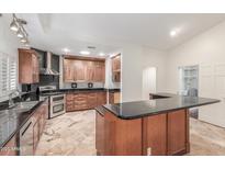 Spacious kitchen featuring stainless steel appliances, black countertops, and lots of cabinet space at 905 E Knight Ln, Tempe, AZ 85284