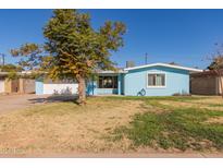 Ranch style home with light blue exterior, landscaped lawn and attached garage at 1054 E 2Nd Pl, Mesa, AZ 85203