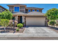 Two-story house with beige exterior, landscaped yard, and two-car garage at 8953 W Townley Ave, Peoria, AZ 85345