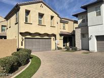 Two-story stucco home showcasing a paved driveway, manicured landscaping, and a two-car garage at 1669 S Wallrade Ln, Gilbert, AZ 85295
