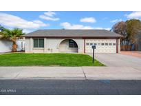 Brick ranch home with a 2-car garage and well-manicured lawn at 2720 W Libby St, Phoenix, AZ 85053