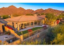 Desert landscape with a covered patio, grassy area, and mountain views at 11157 E Greenway Rd, Scottsdale, AZ 85255