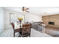 Bright dining room with wood table and chairs, adjacent to living room with fireplace at 3433 W Mescal St, Phoenix, AZ 85029