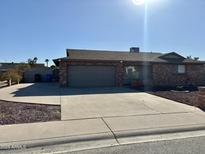 Brick ranch house with a two-car garage and a landscaped front yard at 4643 W Laurel Ln, Glendale, AZ 85304