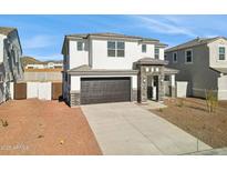 Charming two-story home with a two-car garage and stone accents enhancing curb appeal under a clear blue sky at 7396 W Whitehorn Trl, Peoria, AZ 85383